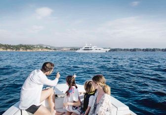 family arrive by tender for their charter vacation on board motor yacht OASIS