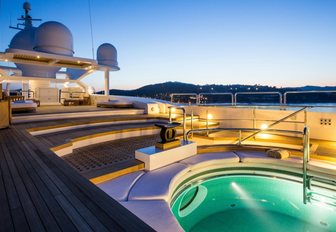 cantilevered sundeck with recessed Jacuzzi lit up at night on board motor yacht Coral Ocean