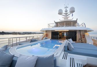 large pool surrounded by sun pads on the flybridge of luxury yacht O’PTASIA 