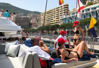 Women in swimsuits on superyacht sunloungers in Monaco harbour