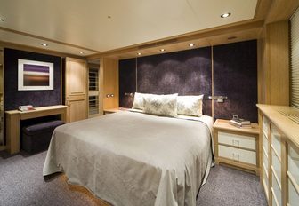 guest cabin with light wooden wall panelling on board superyacht CYAN
