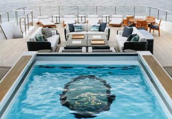 glass bottomed pool on sundeck of luxury yacht elandess, with seating area in background 