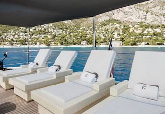line up of sunloungers on the top deck of luxury yacht K
