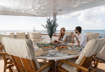 guests enjoy a meal in alfresco dining area on board charter yacht TOUCH