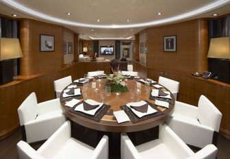 circular dining table in main salon of superyacht destiny