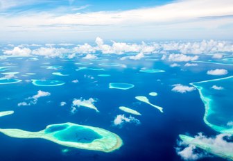 atolls in the maldives, aerial view with little clouds