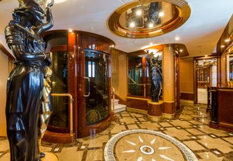 marble-floored foyer with statues and elevator on board charter yacht Mine Games