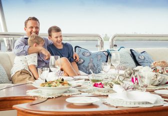 family enjoy dining on the sundeck of superyacht CALYPSO while on a Tahiti yacht charter