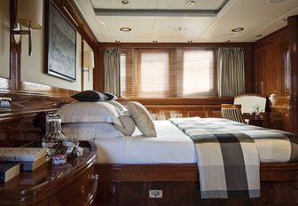 classic cherrywood wall panels and large bed in the master suite of motor yacht Metsuyan IV