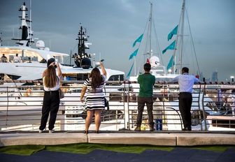 attendees take pictures of the yachts at the Dubai International Boat Show