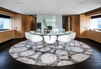 circular, glass table forms formal dining area on upper deck of luxury yacht ‘Mr T’
