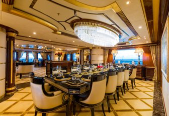 formal dining area underneath glittering chandelier in the main salon of luxury yacht Mine Games