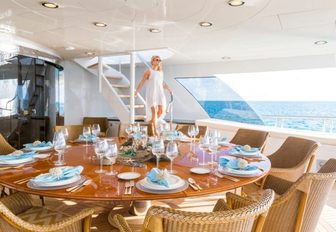 The charter guest on board Amarula Sun during her luxury yacht charter vacation stepping down from her time sunbathing in the sundeck comes down to the alfresco dining area where she will be served a meal by the on board chef 