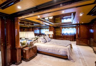 the luxurious and stylish master's quarters in charter yacht Bash featuring large bed, and boasting private study, ensuite facilities, and vanity set up