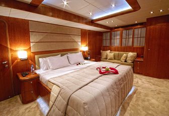 Owner's stateroom on superyacht Annabel II, with warm wood and cream tones