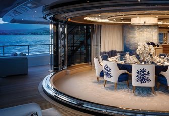 circular dining table surrounded by glass sliding doors on board charter yacht Cloud 9