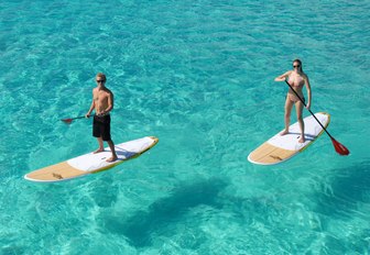 charter guests try out the paddle boards on board motor yacht Sweet Escape 