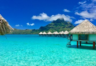 overwater huts and crystal clear blue water in Bora Bora, French Polynesia