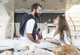 Man and woman eat food on main deck aft on superyacht this is mine in greece