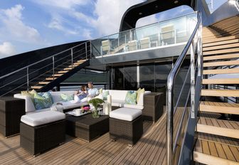 charter guests relax in the seating area on the main deck aft of motor yacht Ocean Emerald 