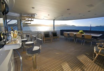 bar and dining table on the upper deck aft of motor yacht De Lisle III