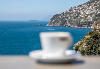 Blurred coffee cup with the Tyrrhenian Sea in the background