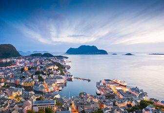 sun sets over a Norwegian coastal town in Fjord Norway