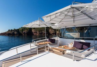 secluded seating area with umbrellas on the foredeck of charter yacht NARVALO 