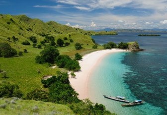 curve of white sand forms a secluded beach in Komodo, Indonesia