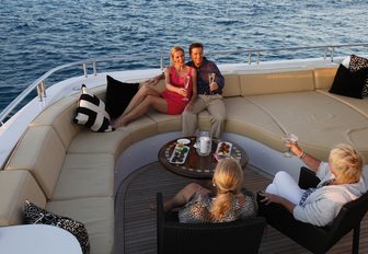 charter guests enjoy drinks on the upper deck aft of motor yacht SOVEREIGN 