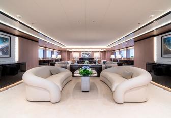 white sofas form a seating area in the main salon of luxury yacht O’Ptasia