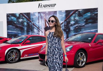 show-goer poses in front of super cars and Feadship stand at the Singapore Yacht Show 2018