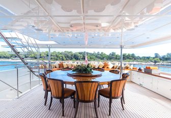 circular alfresco dining table on the upper deck aft of charter yacht Avant Garde 2