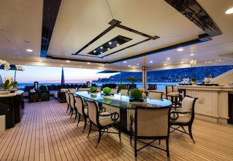Long alfresco dining table on the upper deck aft of superyacht ‘Lioness V’ 
