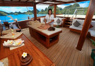 charter guest has a massage on the aft deck of sailing yacht LAMIMA 