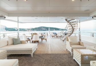 oversized sunbed and al fresco dining area on the deck of motor yacht JOY 