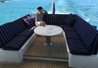 charter guest relaxes on the aft deck seating area aboard motor yacht ‘Crystal Blue’ 