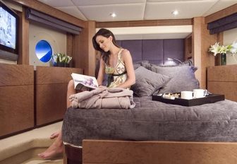 charter guests reads a book in master suite aboard luxury yacht ‘Crystal Blue’ 