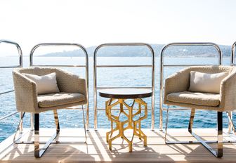 table and chairs on side balcony of luxury yacht BLUSH