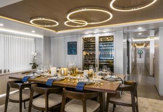 formal dining area with bespoke wine storage unit in the main salon aboard superyacht Broadwater 