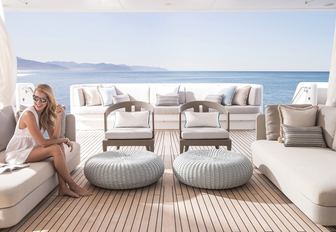 charter guests unwind in tranquil seating area on main deck aft of motor yacht TURQUOISE