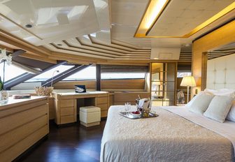 Master suite with large windows and cream furnishings on board charter yacht RINI