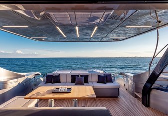 Open air dining area and sofa on motor yacht BEYOND with sea in background