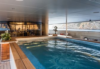 The large swimming pool fitted beneath shading on board Amels superyacht 'Here Comes The Sun'
