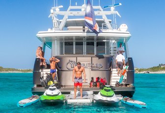 guests hang out alongside water toys on the swim platform of luxury yacht UNBRIDLED 