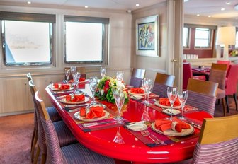 dining area with red lacquer table in the main salon aboard motor yacht Cheetah Moon