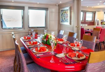 dining area with red lacquer table in the main salon aboard motor yacht Cheetah Moon
