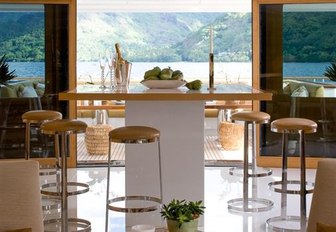 square counter surrounded by bar stools in the main salon of luxury yacht HELIOS