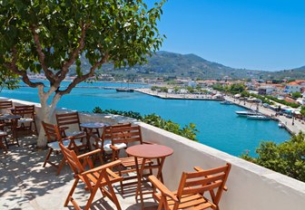 Terrace with table a chairs overlooking the cyan-blue sea on Skopelos island in the Sporades, Greece