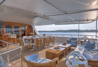 al fresco dining table, bar and seating area on the upper deck aft of motor yacht CYNTHIA